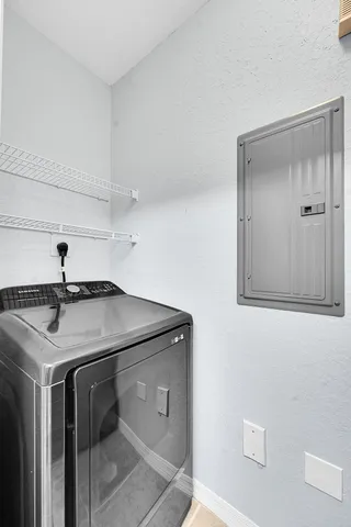 a utility room with a sink and mirror