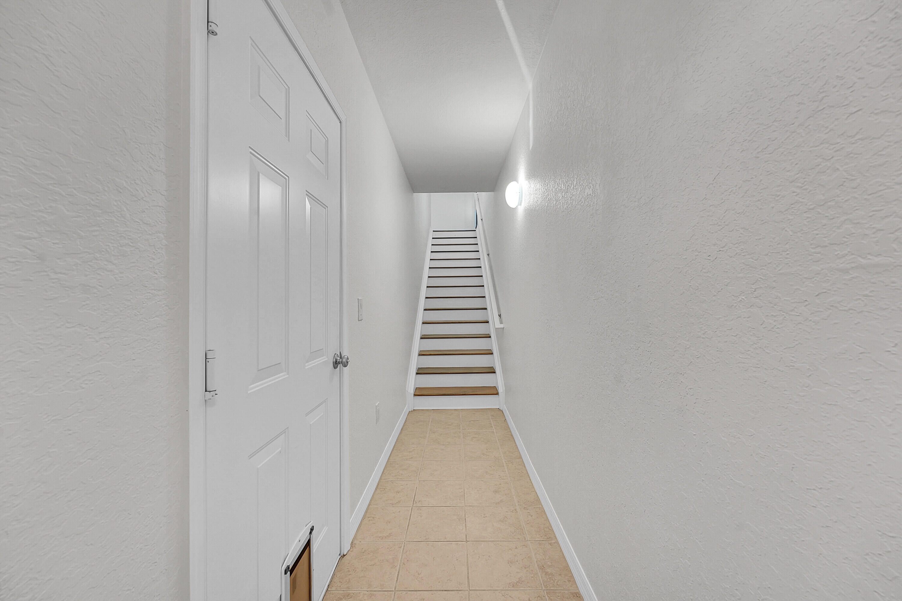 162 Southwest Peacock Boulevard, Unit 32206 Port St. Lucie, FL 34986 - Photo 14 of 24 a view of a hallway with stairs