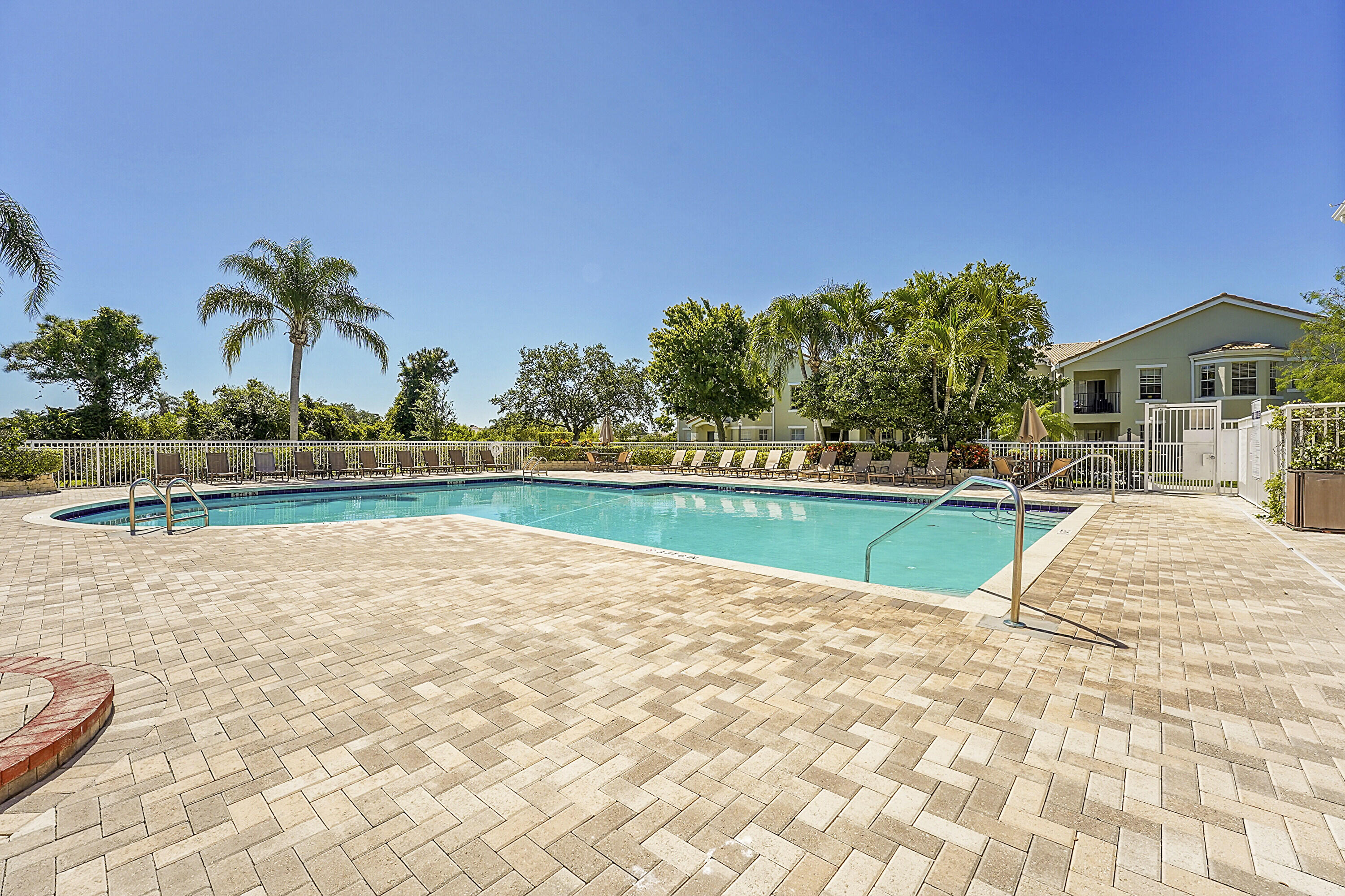162 Southwest Peacock Boulevard, Unit 32206 Port St. Lucie, FL 34986 - Photo 23 of 24 a view of a house with a swimming pool and a yard