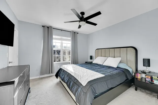 a bedroom with a bed and a flat tv screen on the dresser