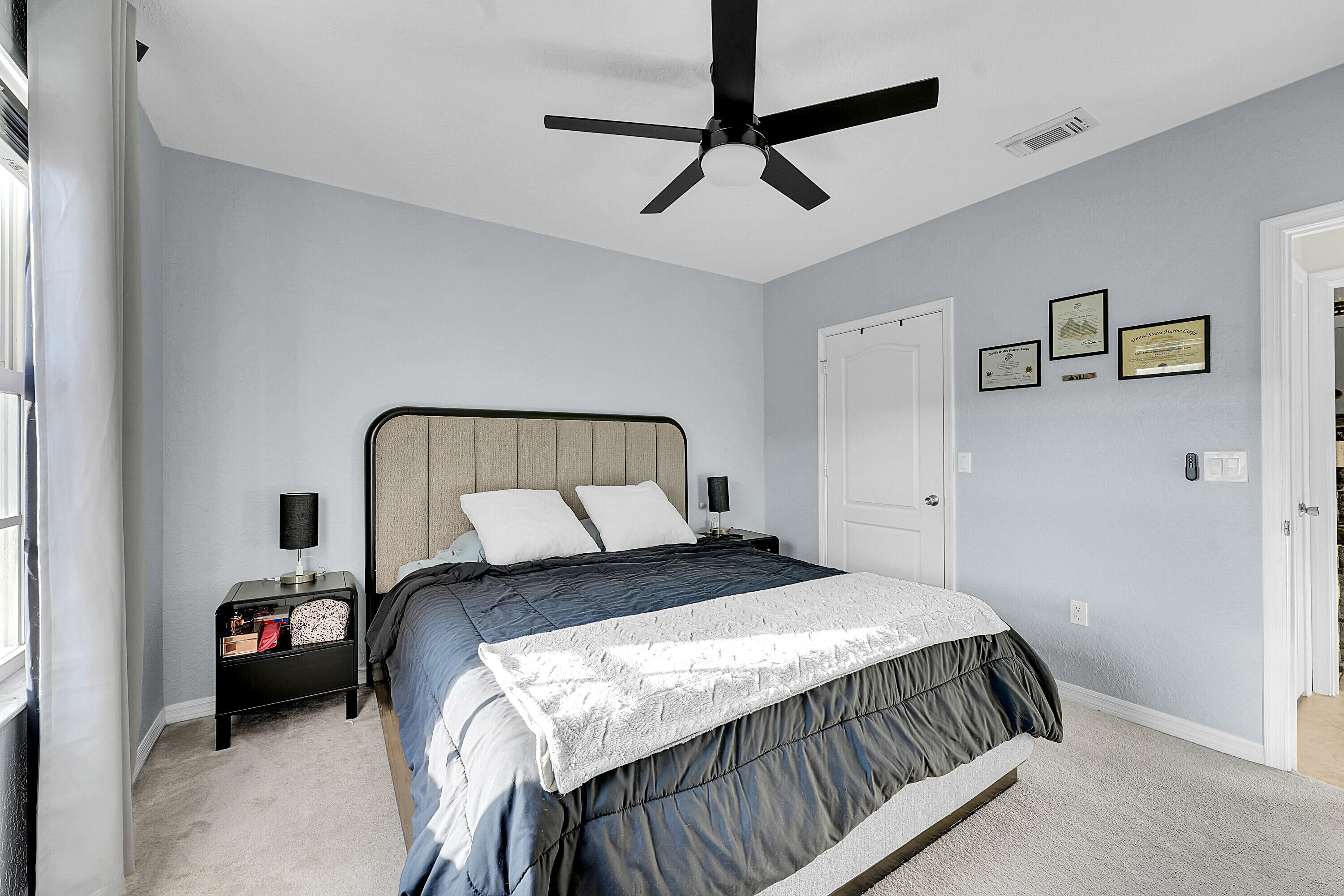 162 Southwest Peacock Boulevard, Unit 32206 Port St. Lucie, FL 34986 - Photo 10 of 24 a bedroom with a bed and a chandelier