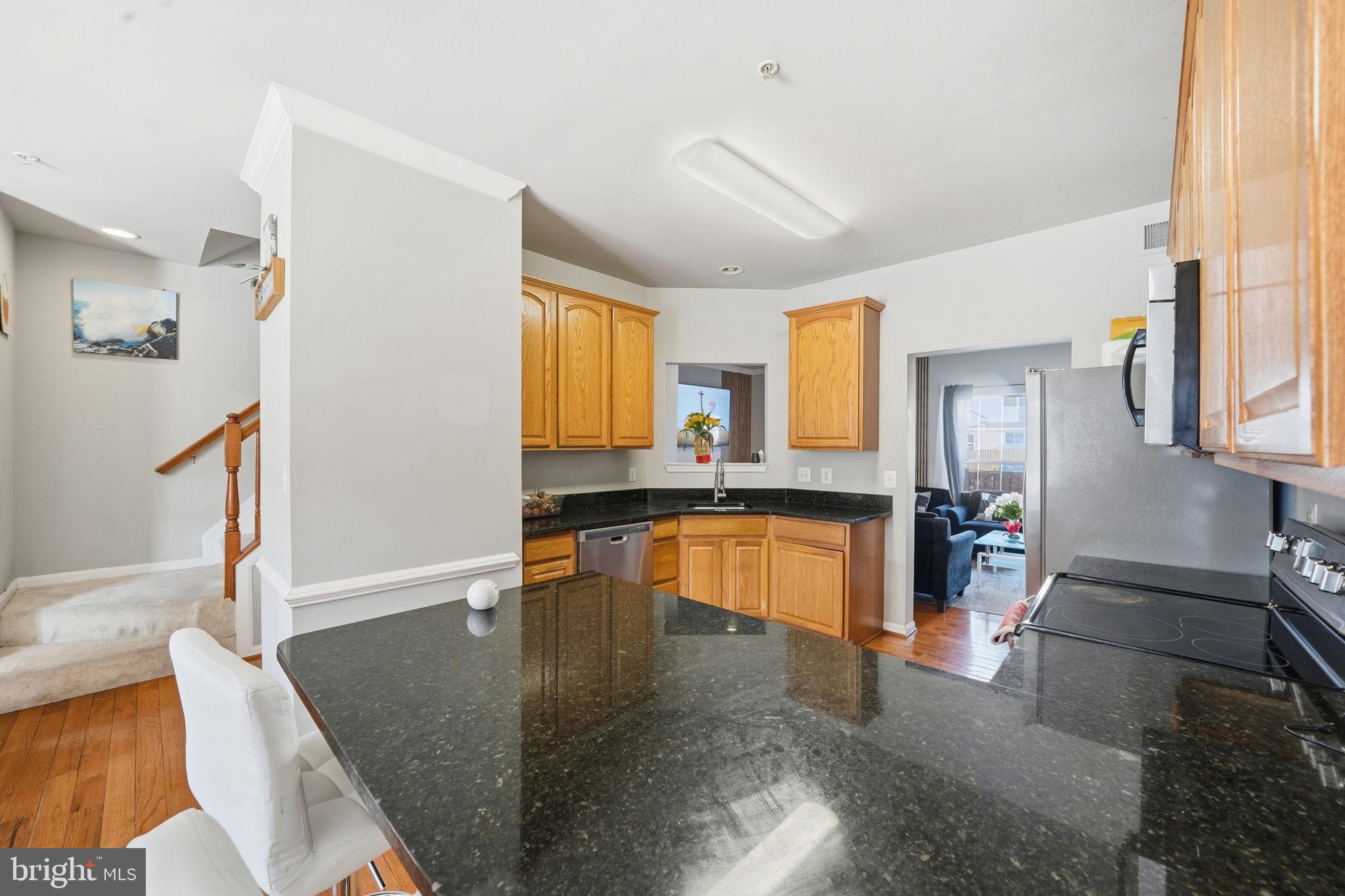 15420 Kennett Square Way Brandywine, MD 20613 - Photo 11 of 32 a large kitchen with stainless steel appliances granite countertop a sink and a large window