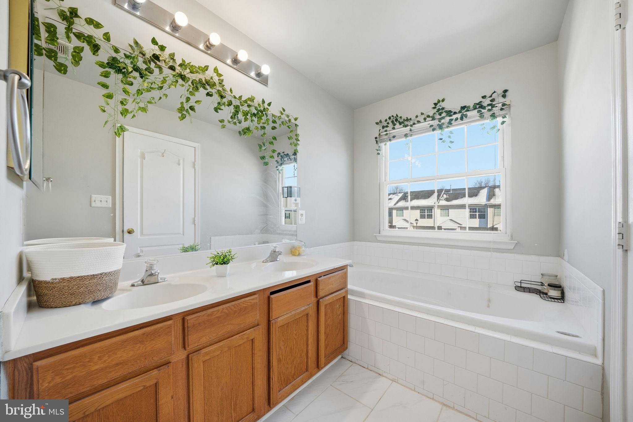 15420 Kennett Square Way Brandywine, MD 20613 - Photo 18 of 32 a spacious bathroom with a granite countertop tub sink and mirror