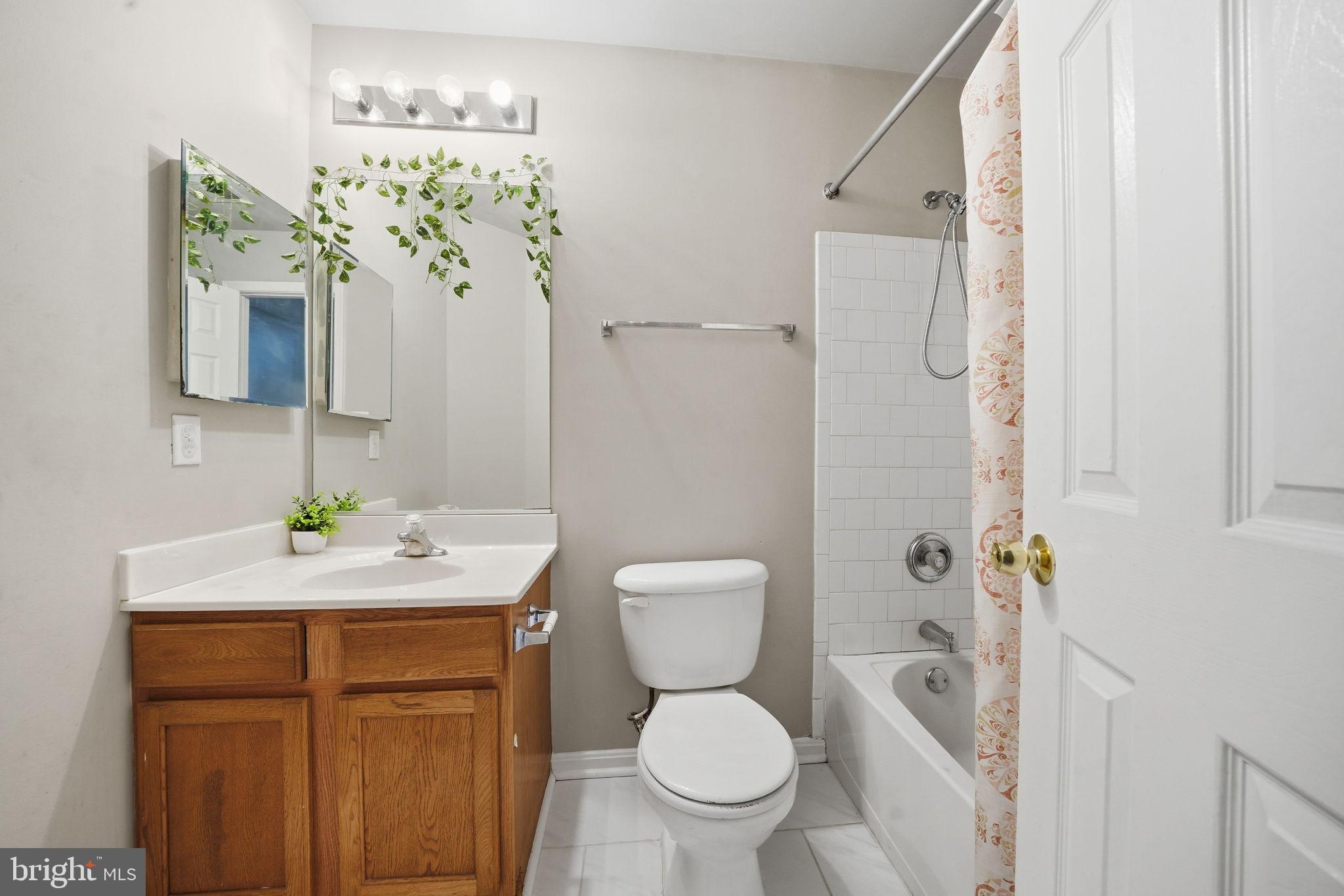 15420 Kennett Square Way Brandywine, MD 20613 - Photo 21 of 32 a bathroom with a sink a toilet and shower curtain