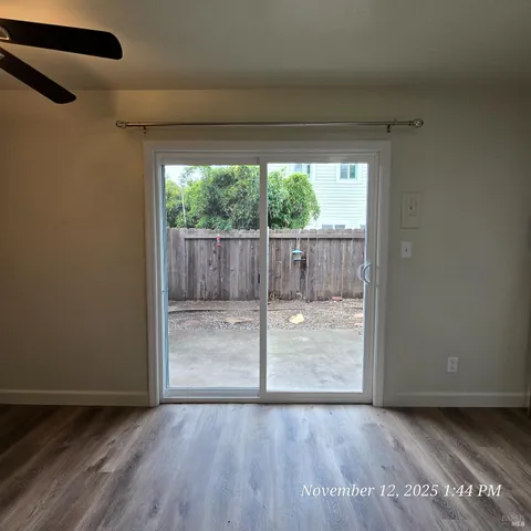 a view of a room with wooden floor and doors