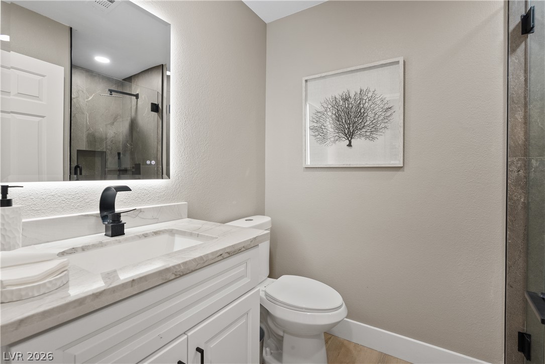 1662 Ravanusa Drive Henderson, NV 89052 - Photo 53 of 74 A well-appointed bathroom features a sleek vanity with a modern black faucet and an illuminated mirror.