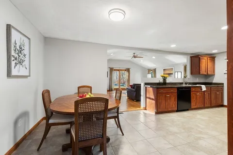 a kitchen with stainless steel appliances granite countertop a stove a sink a dining table and chairs