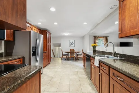 a kitchen with stainless steel appliances granite countertop a sink dishwasher stove and refrigerator