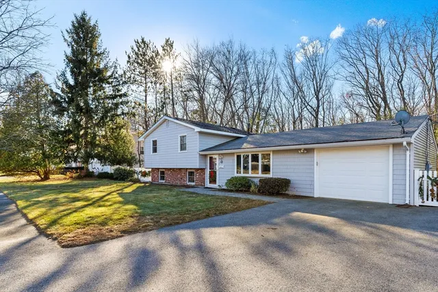 a view of a house with a yard and large trees
