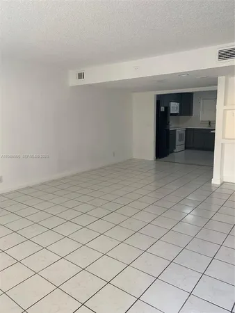an empty room with a fireplace and cabinet