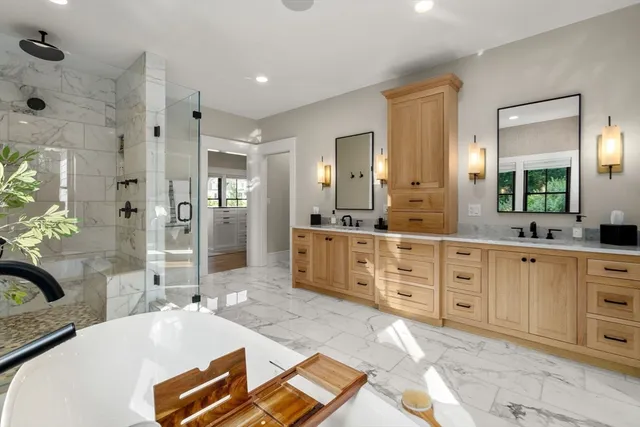a spacious bathroom with a double vanity sink a large mirror and a shower