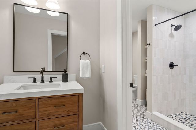 a bathroom with a double vanity sink a shower and a mirror