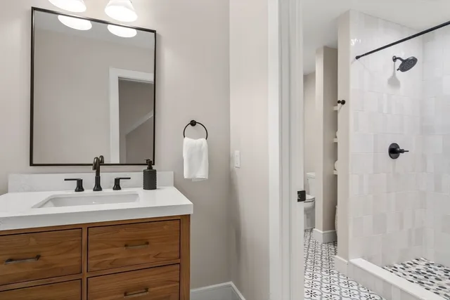 a bathroom with a double vanity sink a shower and a mirror