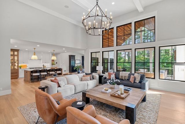 a living room with furniture a chandelier and a dining table