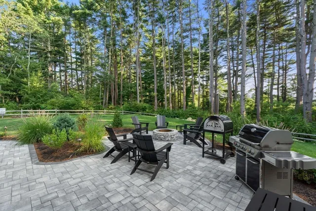 a view of a patio with table and chairs potted plants and a large tree