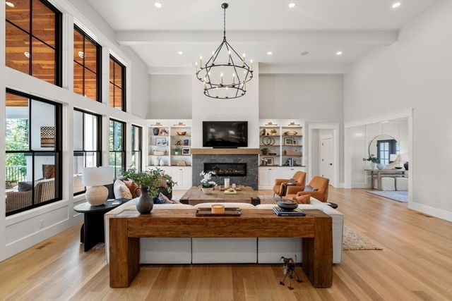 a living room with fireplace furniture and a large window