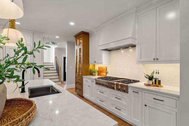 a kitchen with stainless steel appliances kitchen island granite countertop a sink a stove and a refrigerator