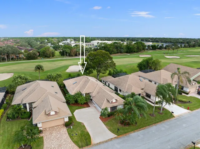 an aerial view of a house with a garden and lake view