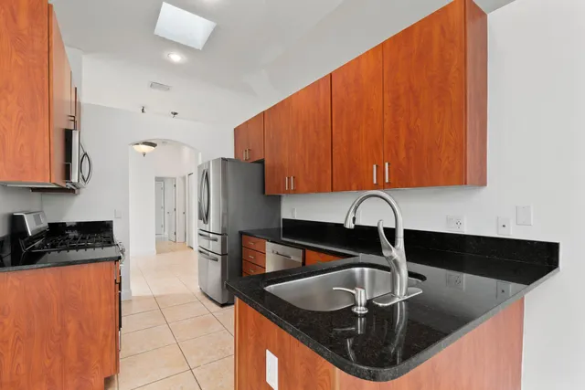 a kitchen with stainless steel appliances granite countertop a sink a stove and a cabinets