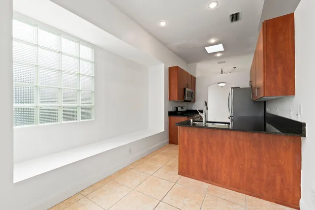 a kitchen with stainless steel appliances granite countertop a stove a sink and a refrigerator