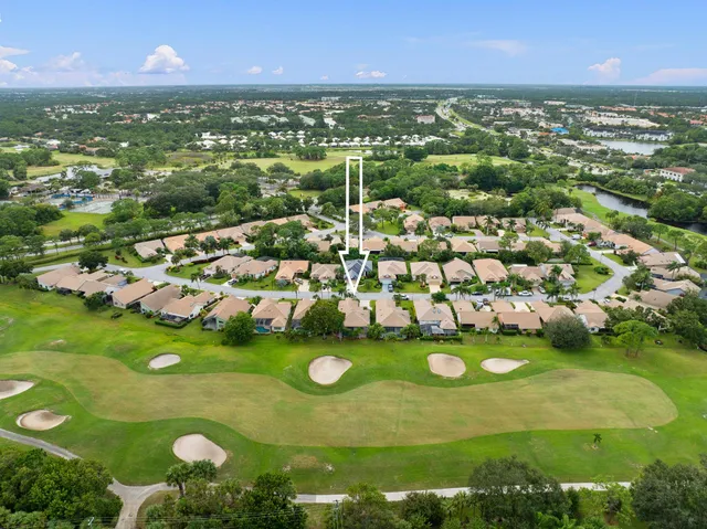 an aerial view of a house with a garden and lake view