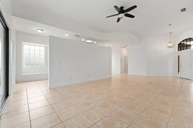 a view of an empty room and a ceiling fan window