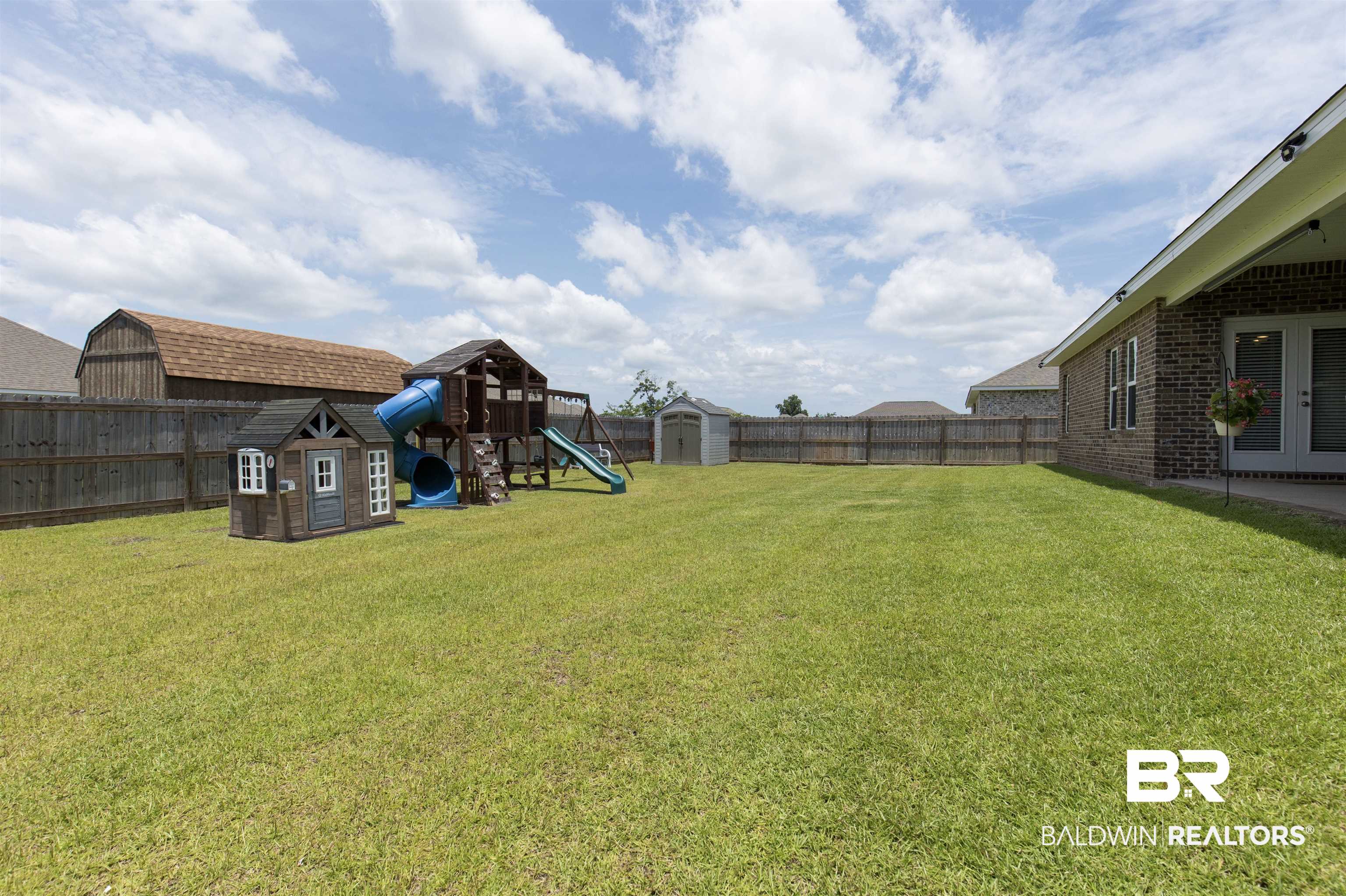 2345 Laurel Street Semmes, AL 36575 - Photo 26 of 31 Fenced backyard with a shed, a playground, and french doors