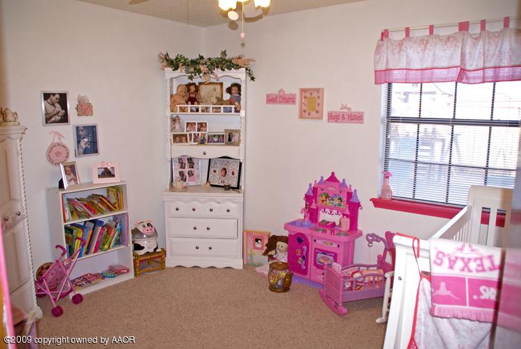 5301 Capulin Lane Amarillo, TX 79110 - Photo 14 of 18 a bedroom with furniture and a book shelf
