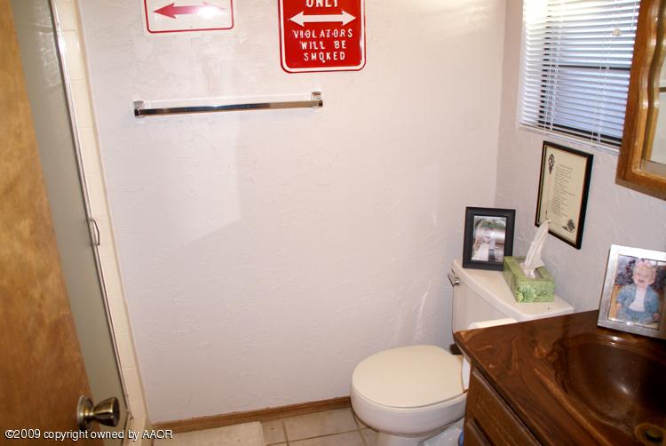 5301 Capulin Lane Amarillo, TX 79110 - Photo 15 of 18 a white toilet sitting next to a bathroom sink