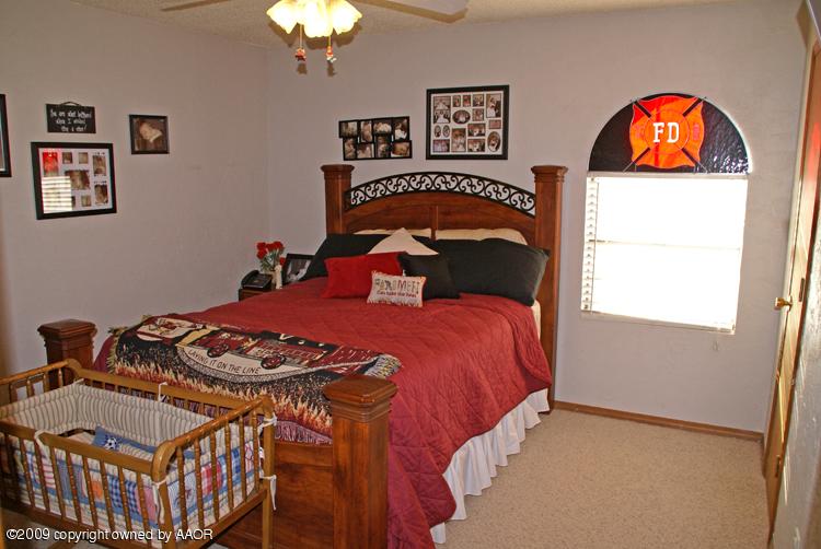 5301 Capulin Lane Amarillo, TX 79110 - Photo 17 of 18 a bedroom with a bed and a chandelier