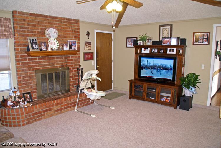 5301 Capulin Lane Amarillo, TX 79110 - Photo 5 of 18 a living room with furniture a flat screen tv and a fireplace