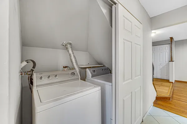 a view of washer and dryer with bathroom in the background