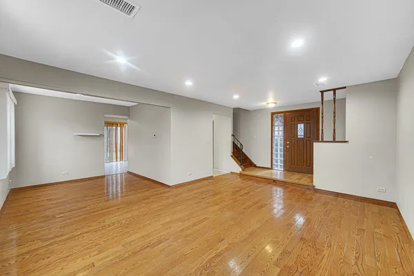a view of empty room with wooden floor