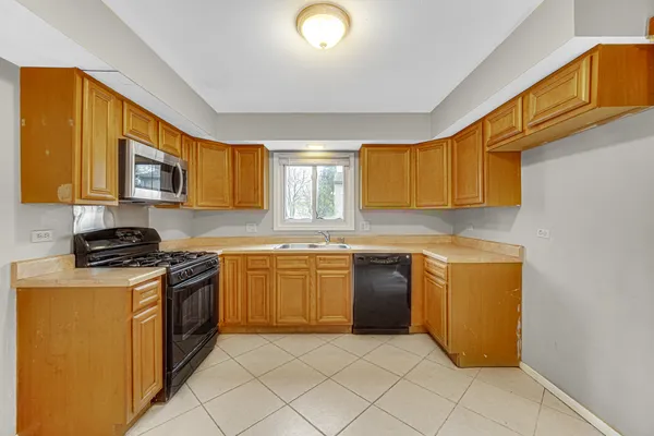 a kitchen with stainless steel appliances granite countertop a stove a sink dishwasher and a microwave oven with a dishwasher