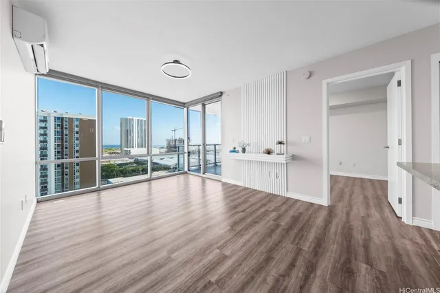 a view of empty room with wooden floor and fan