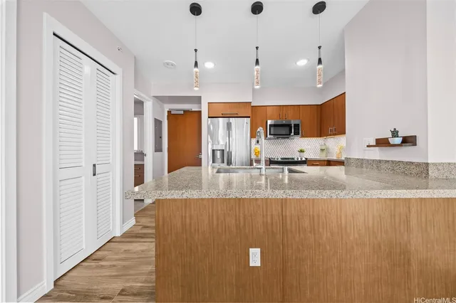 a large kitchen with stainless steel appliances granite countertop a granite counter tops and a view of living room