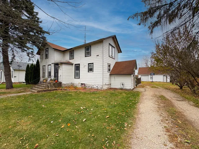 a backyard of a house with table and chairs