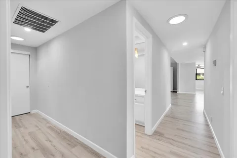 a view of a hallway with wooden floor