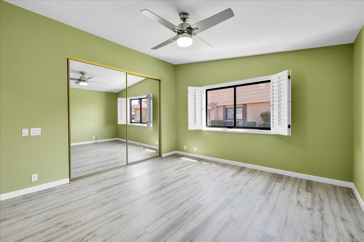 49 Maximo Way Palm Desert, CA 92260 - Photo 16 of 33 an empty room with wooden floor a ceiling fan and windows