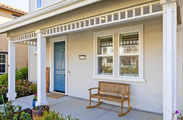 a view of front door of house with a chair and bench