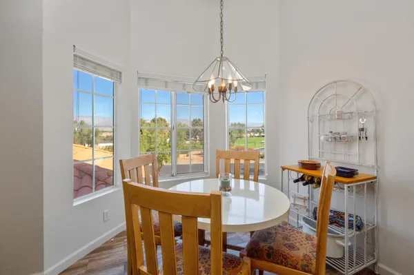 a dining room with furniture a chandelier and wooden floor