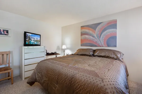 a bedroom with a bed and a painting on the wall
