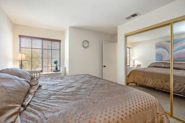 a bedroom with a large bed and a large mirror