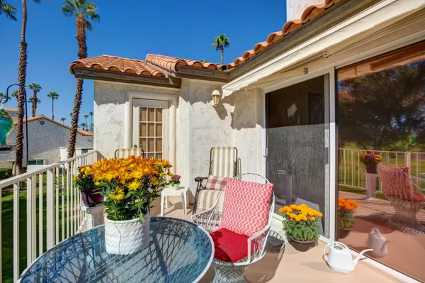 a view of a patio with table and chairs potted plants