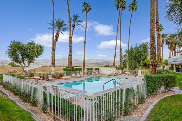 a view of a swimming pool with a chair and table in the patio