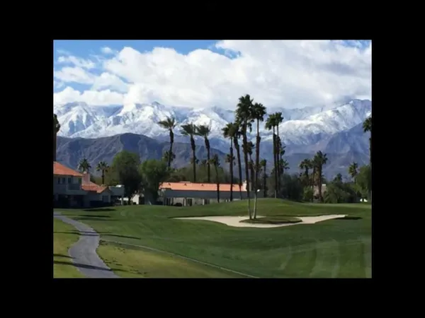 a view of a golf course with a lake in the background