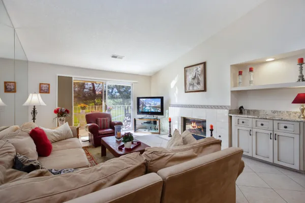 a living room with furniture a fireplace and a flat screen tv