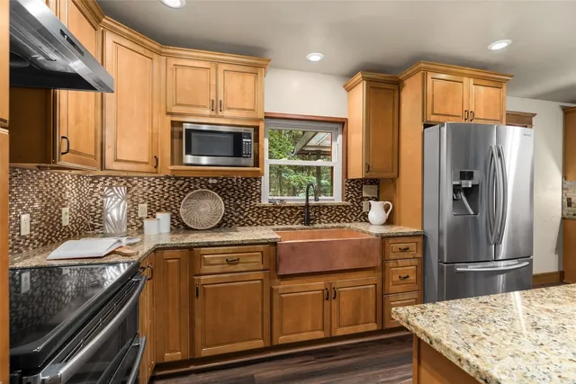 a kitchen with granite countertop stainless steel appliances and wooden cabinets