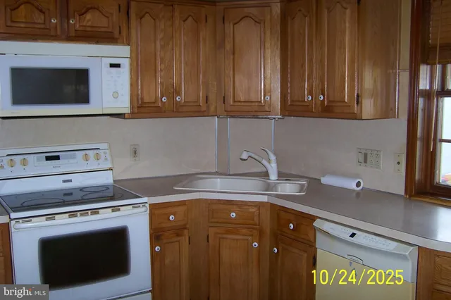 a kitchen with stainless steel appliances granite countertop a sink a stove and cabinets