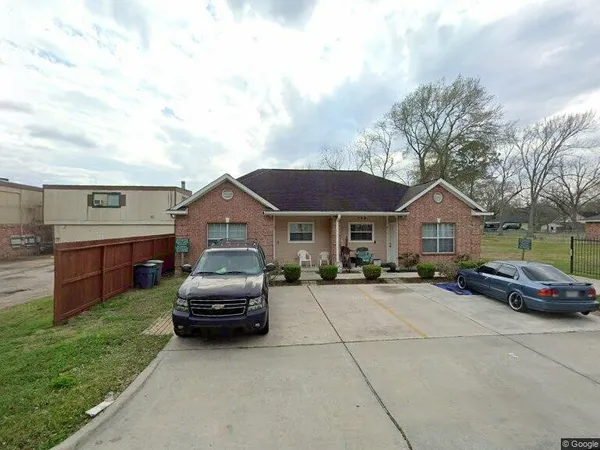 a car parked in front of a house with yard